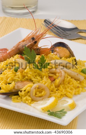 Spanish Cuisine. Paella. Spanish rice in a white square plate. Selective focus.