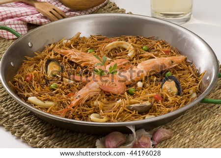 Spanish cuisine. Fideua. Seafood spaghetti cooked in a typical paellera.
