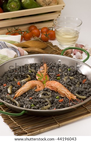 Spanish cuisine. Arroz negro. Black rice cooked in squid ink. Served in a typical paellera.