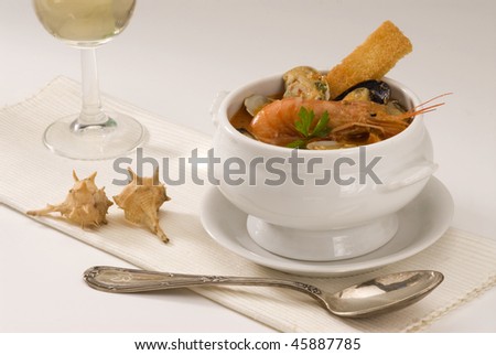 Spanish cuisine. Seafood soup served in a white bowl. Selective focus. Sopa de pescado.