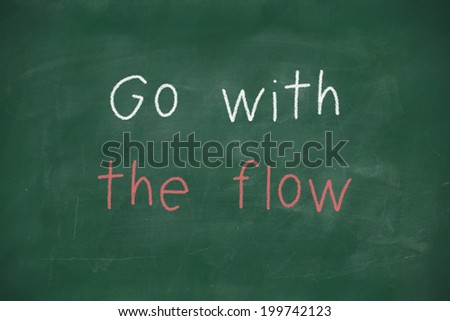 Go with the flow handwritten on school blackboard