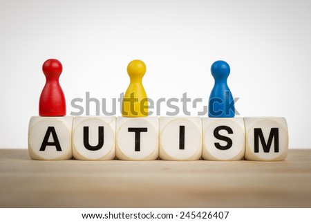 Autism concept: Pawns in different colors on top of toy dice