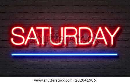 Saturday neon sign glowing on club wall with bricks