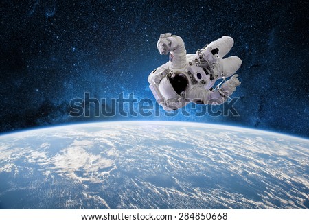 Astronaut in outer space with planet earth as backdrop. Elements of this image furnished by NASA.