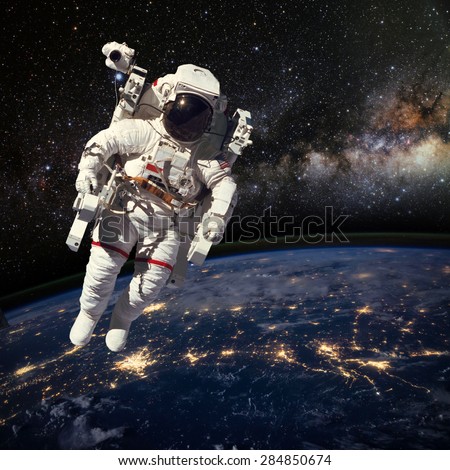 Astronaut in outer space above the earth during night time. Elements of this image furnished by NASA.