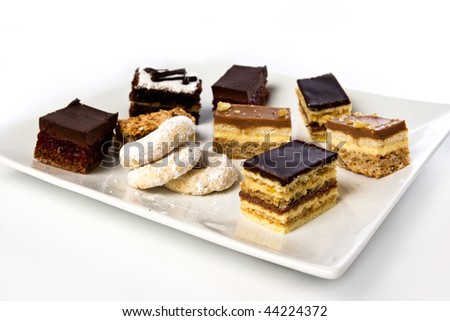lots of cakes and cookies on a plate isolated on white