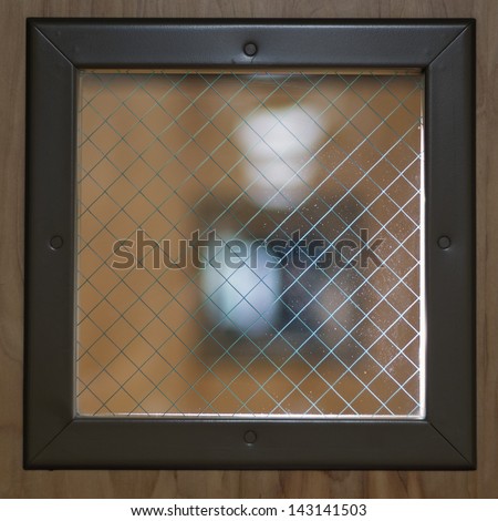 A window made of wire mesh glass, which is designed to resist breaking in a fire.