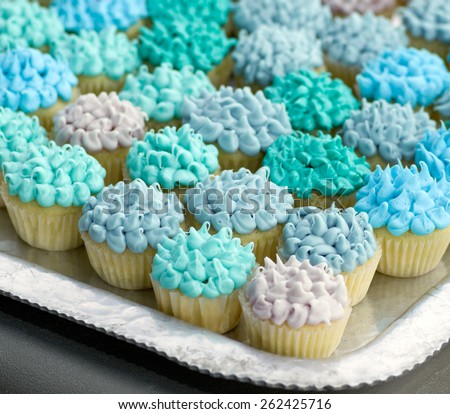 Many mini cupcakes with various shades of blue frosting.