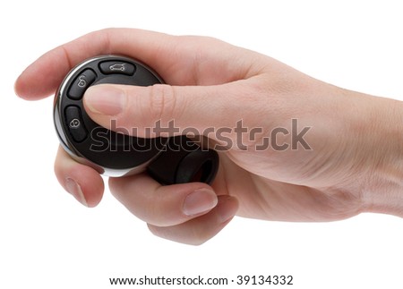 A woman\'s hand holding the remote key fob for a modern automobile