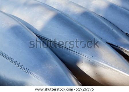 Abstract water sports background: hulls of aluminum canoes