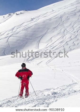 A person looks back at the beautiful powder field that he just skied