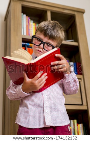 boy with funny glasses reading a book