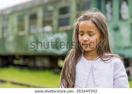 little thai girl in front of train carriage. shallow depth of field. this image looks great in black & white, or sepia.