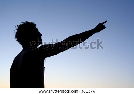 Silhouette of man pointing at something far away