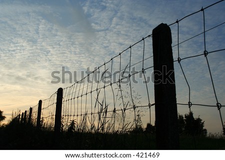 Silhouette of a fence at dusk