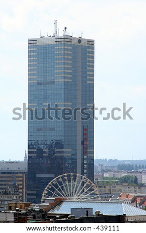 Office tower in Brussels, Belgium. In front of the tower is a ferris wheel