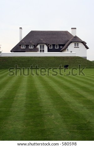 A nice house with green grass in front of it. (Ideal copyspace)