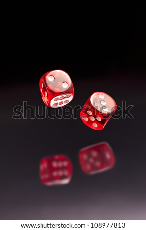Rolling red dice over black grey background