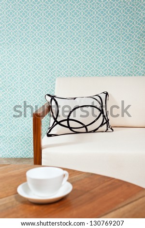 Bright white furniture in a living room with turquoise blue wallpaper