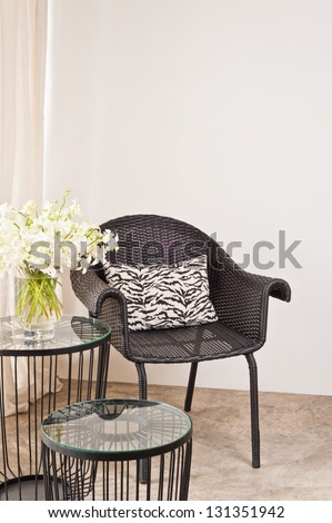 Brown rattan Chair in interior setting in front of a white wall