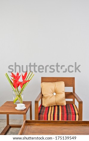 Beige Upholstered Chair With Side Table And Flowers