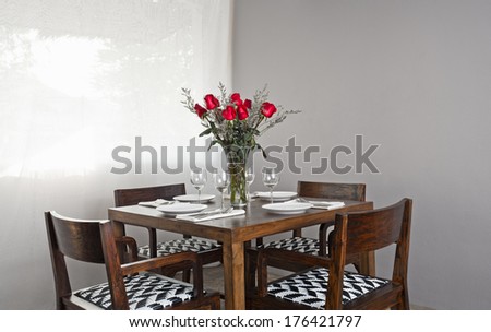 Dinner table setup for four with red roses