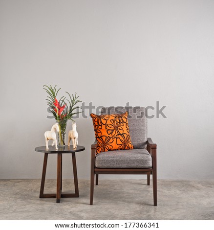 Grey upholstered chair in living room with flowers