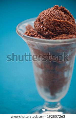 Chocolate ice cream cup over blue background
