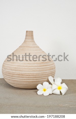 Empty vase decorated with Frangipani flower over side board