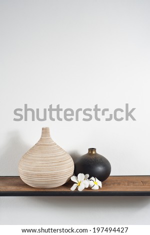 Empty vases decorated with Frangipani flower over side board
