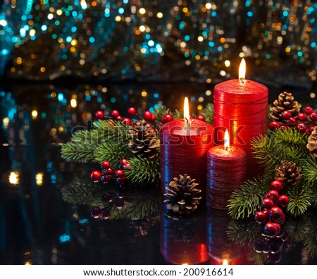 Three red Candles with Christmas tree branches and pine cones decorated