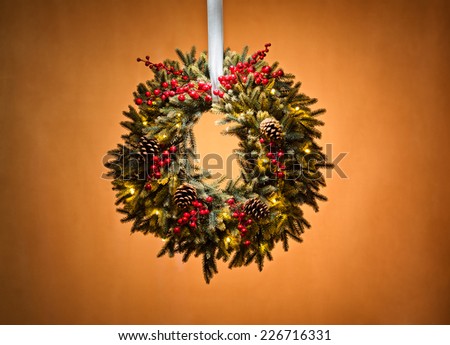 Advent wreath over beige background with red berries