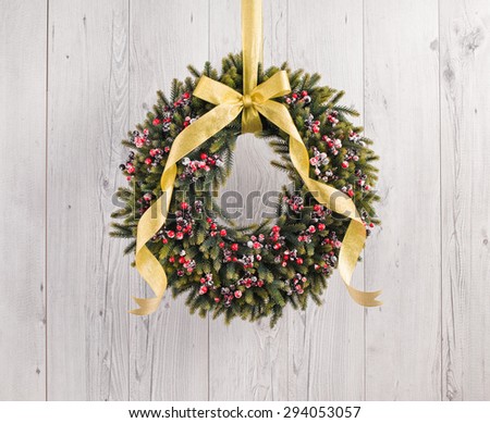 Green advents wreath with autumn decoration in front of a white wooden background