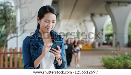 Woman work on smart phone at park