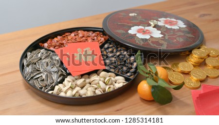 Traditional Chinese new year snack tray with red packet words mean luck and gold coin word means wealth
