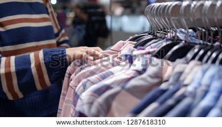 Woman shopping for clothes fashion designer browsing wardrobe