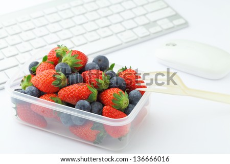 Healthy lunch with strawberry and blueberry mix in office