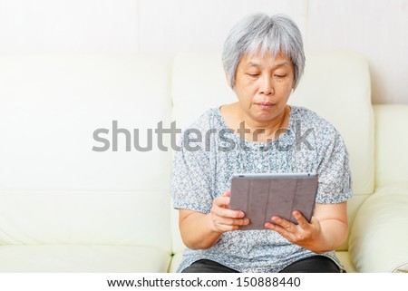 Asian old woman using digital tablet