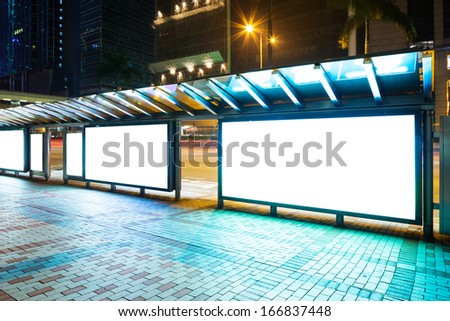 Night bus station with blank billboard