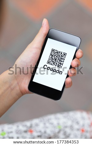 QR coupon on mobile display holding by woman hand