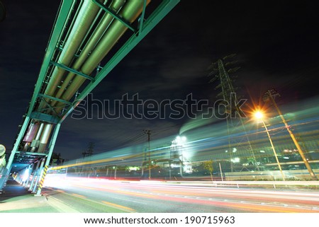 Industrial factory with traffic trail at night