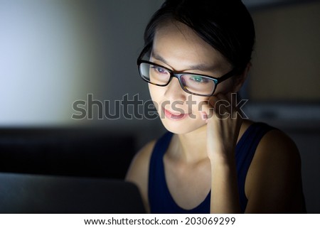 Asian woman look at computer screen at night