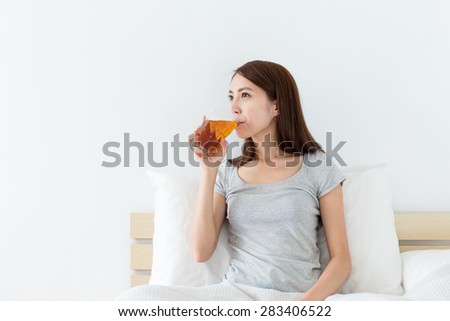 Chinese woman drink a cup of tea on bed