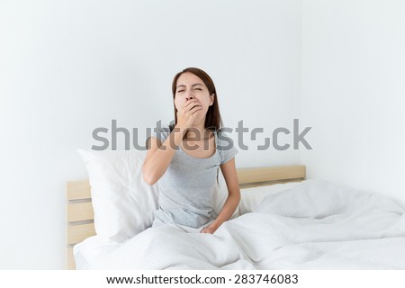 Young wake up yawning and hand cover her mouth