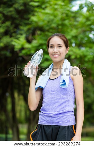 Sporty woman take a break and holding a bottle of water