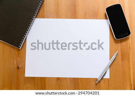 Empty White paper on desk with cellphone for adding information