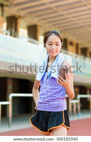 Asain Woman listen to song with cellphone in sport arena