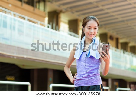 Woman listen to song with mobile phone in sport stadium