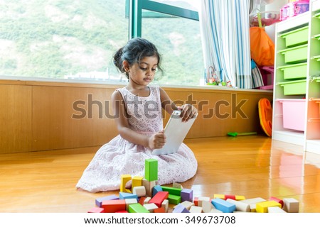 Little girl play tablet pc at her toy room