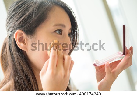Woman using powder to touch up on her face
